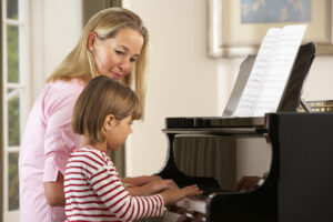 Young girl playing piano in music lesson