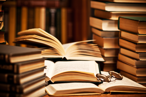 opened book, lying on the bookshelf with a glasses