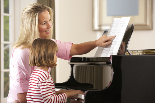 Young girl playing piano in music lesson